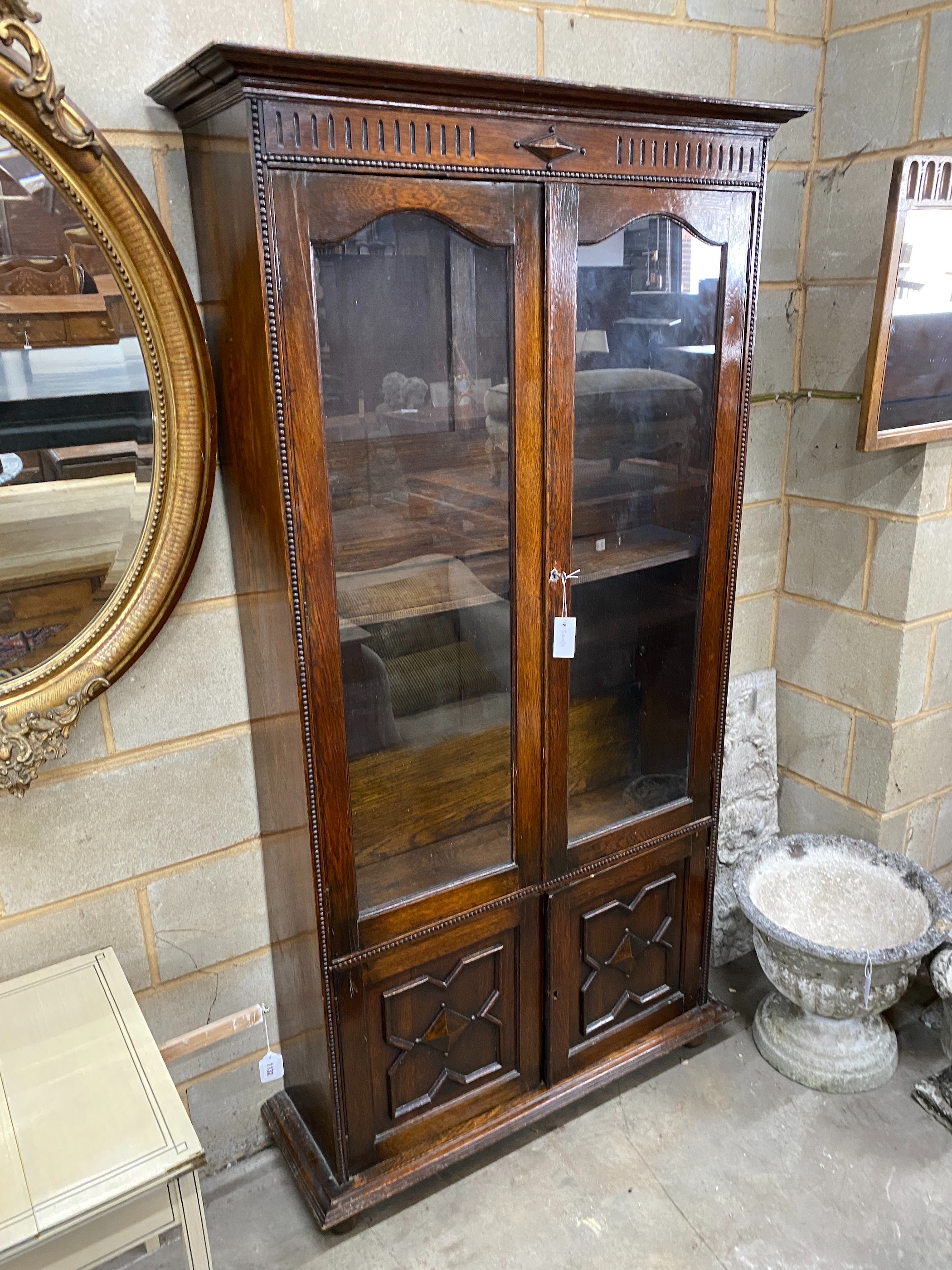 A 1920's glazed oak two door bookcase, width 100cm, depth 32cm, height 192cm